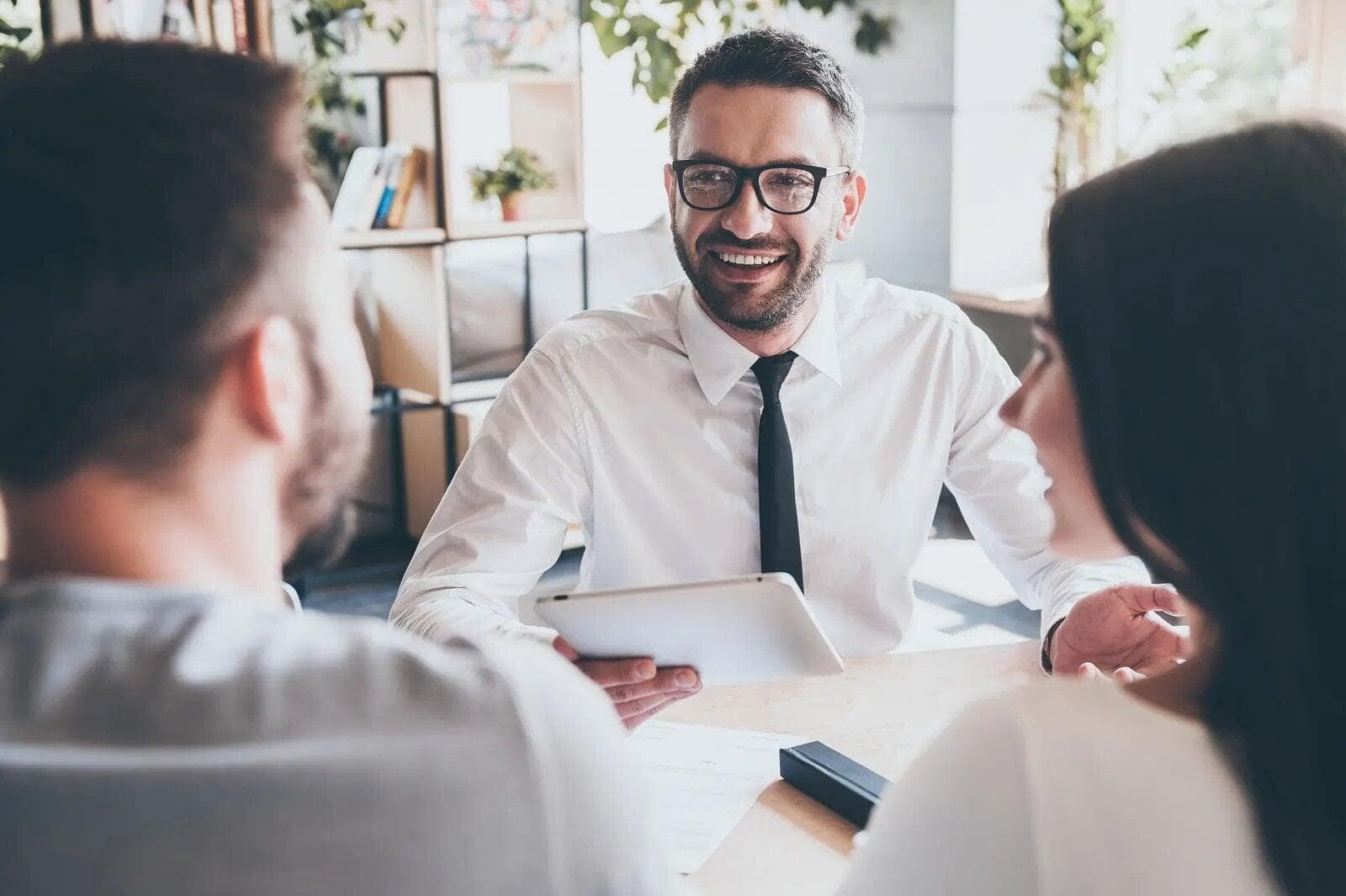 Advisor smiling across the desk at clients